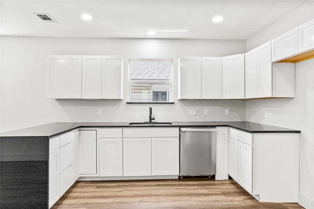 1127 West Morgan Street Denison, TX 75020 - Photo 4 of 23 a kitchen with stainless steel appliances granite countertop a sink and a stove top oven