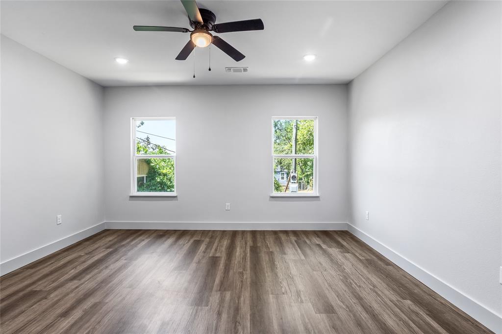 1127 West Morgan Street Denison, TX 75020 - Photo 6 of 23 wooden floor in an empty room with a window