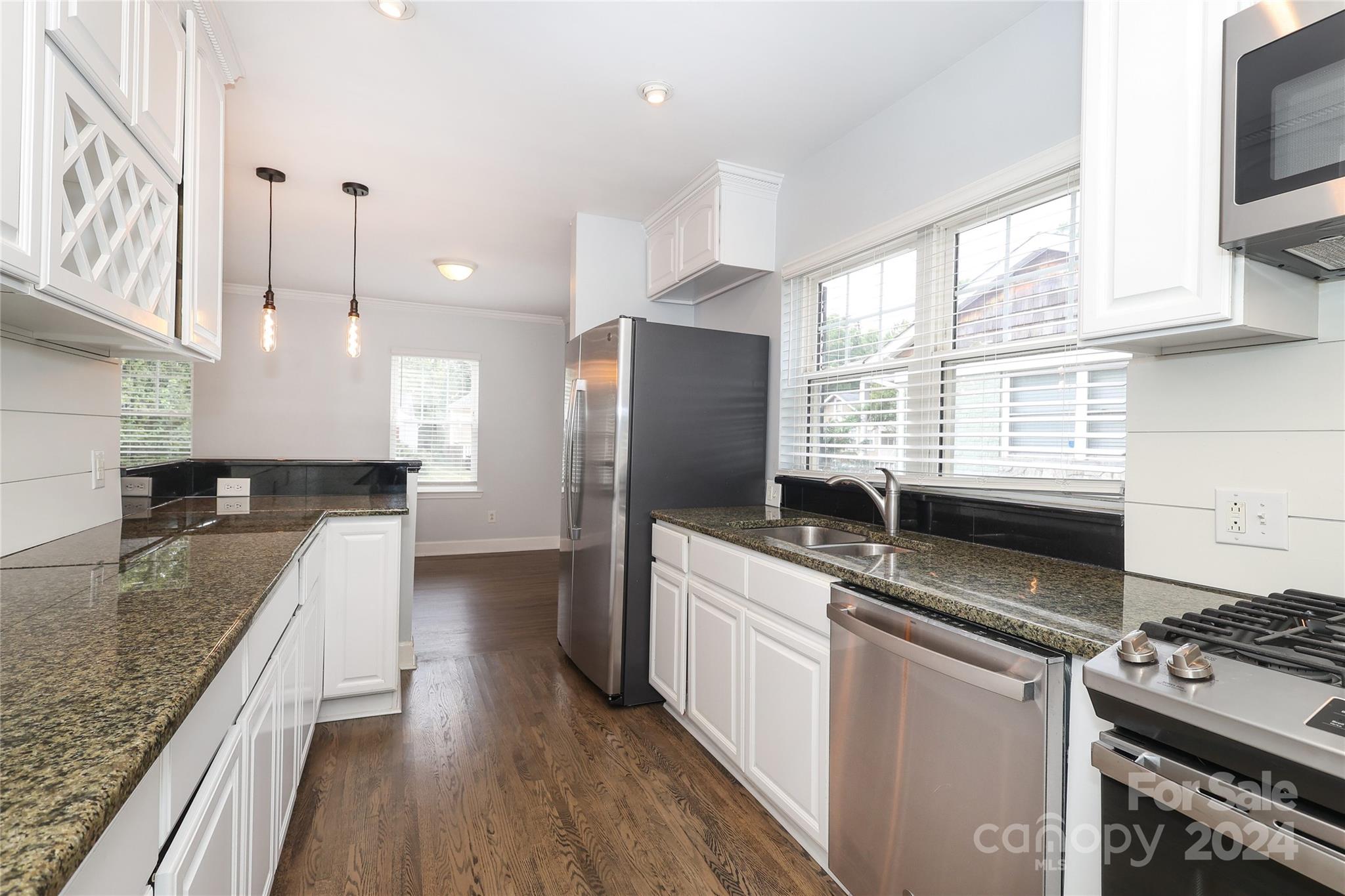 2012 Scott Avenue Charlotte, NC 28203 - Photo 14 of 43 a kitchen with stainless steel appliances granite countertop a sink stove and refrigerator