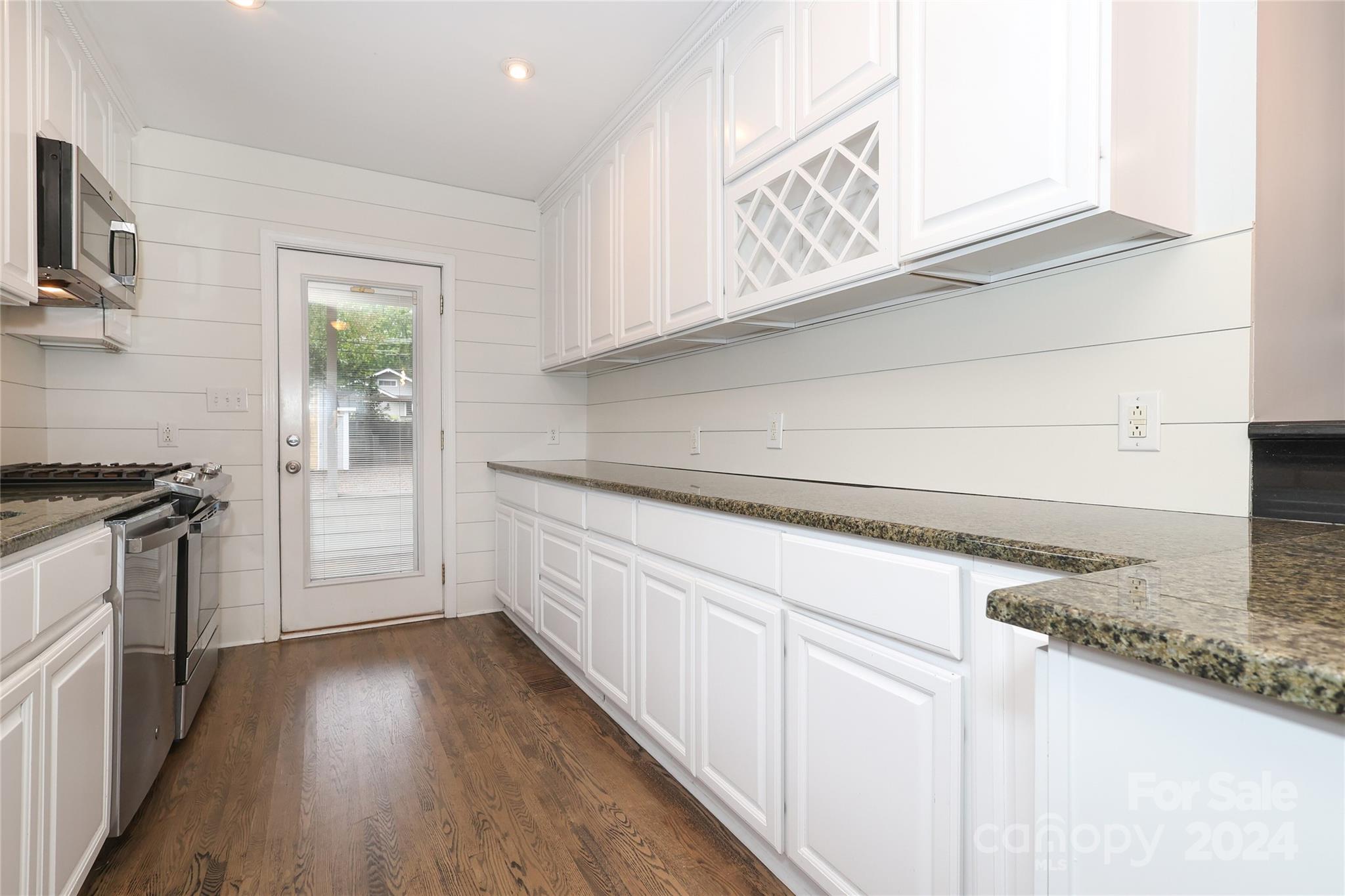 2012 Scott Avenue Charlotte, NC 28203 - Photo 17 of 43 a kitchen with granite countertop a stove a sink and a refrigerator