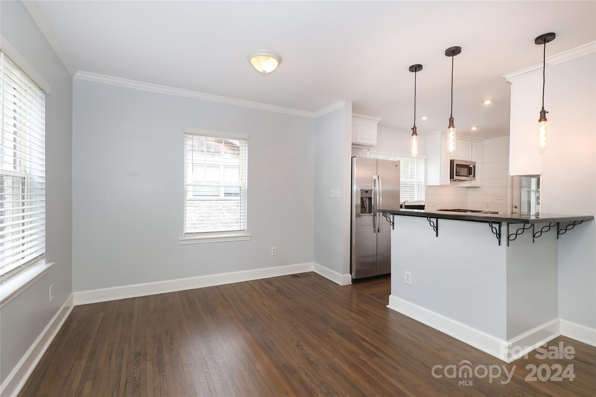 2012 Scott Avenue Charlotte, NC 28203 - Photo 10 of 43 a kitchen with stainless steel appliances granite countertop a refrigerator a sink and a wooden floor