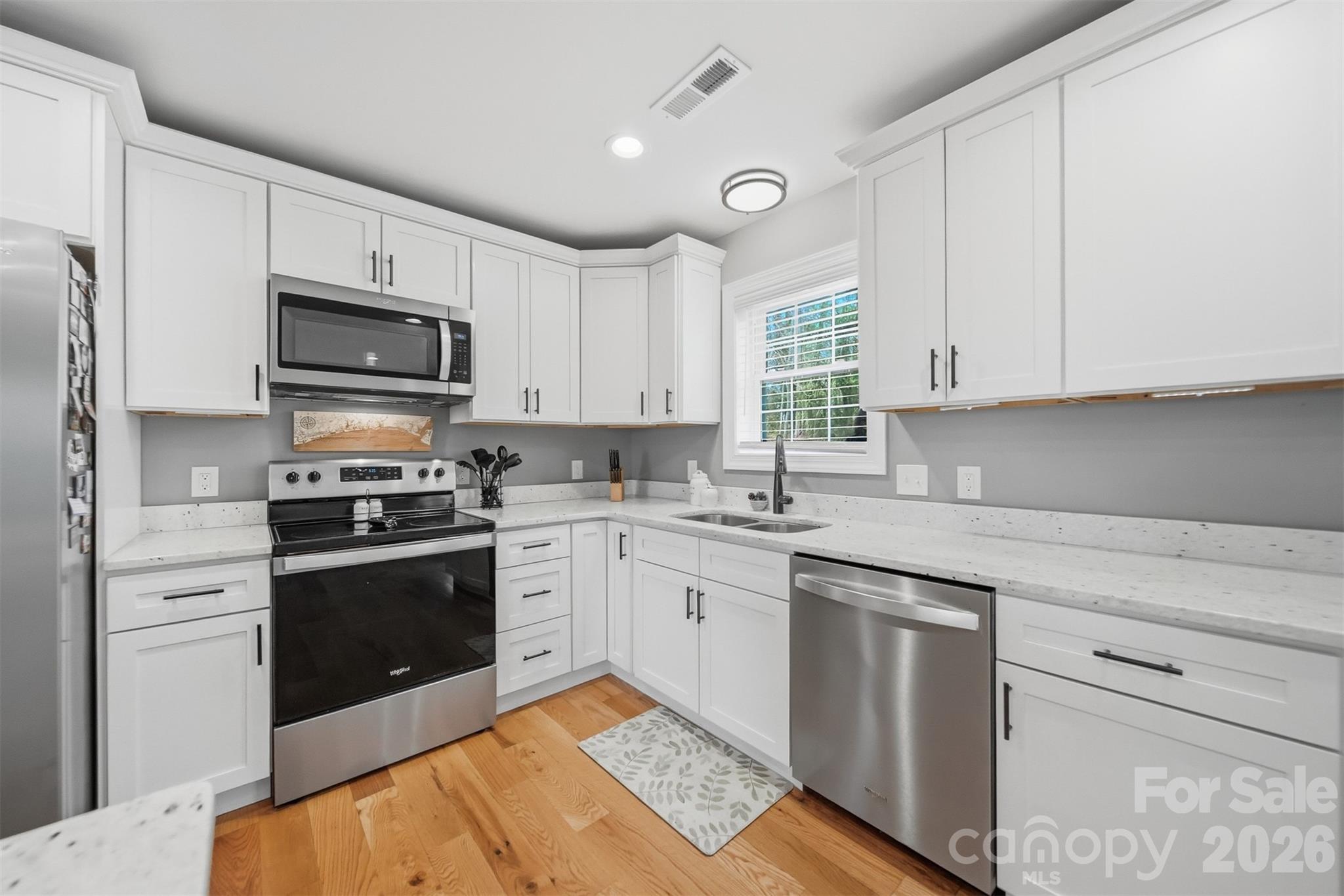 490 Dudley Shoals Road Granite Falls, NC 28630 - Photo 13 of 38 a kitchen with granite countertop white cabinets and stainless steel appliances