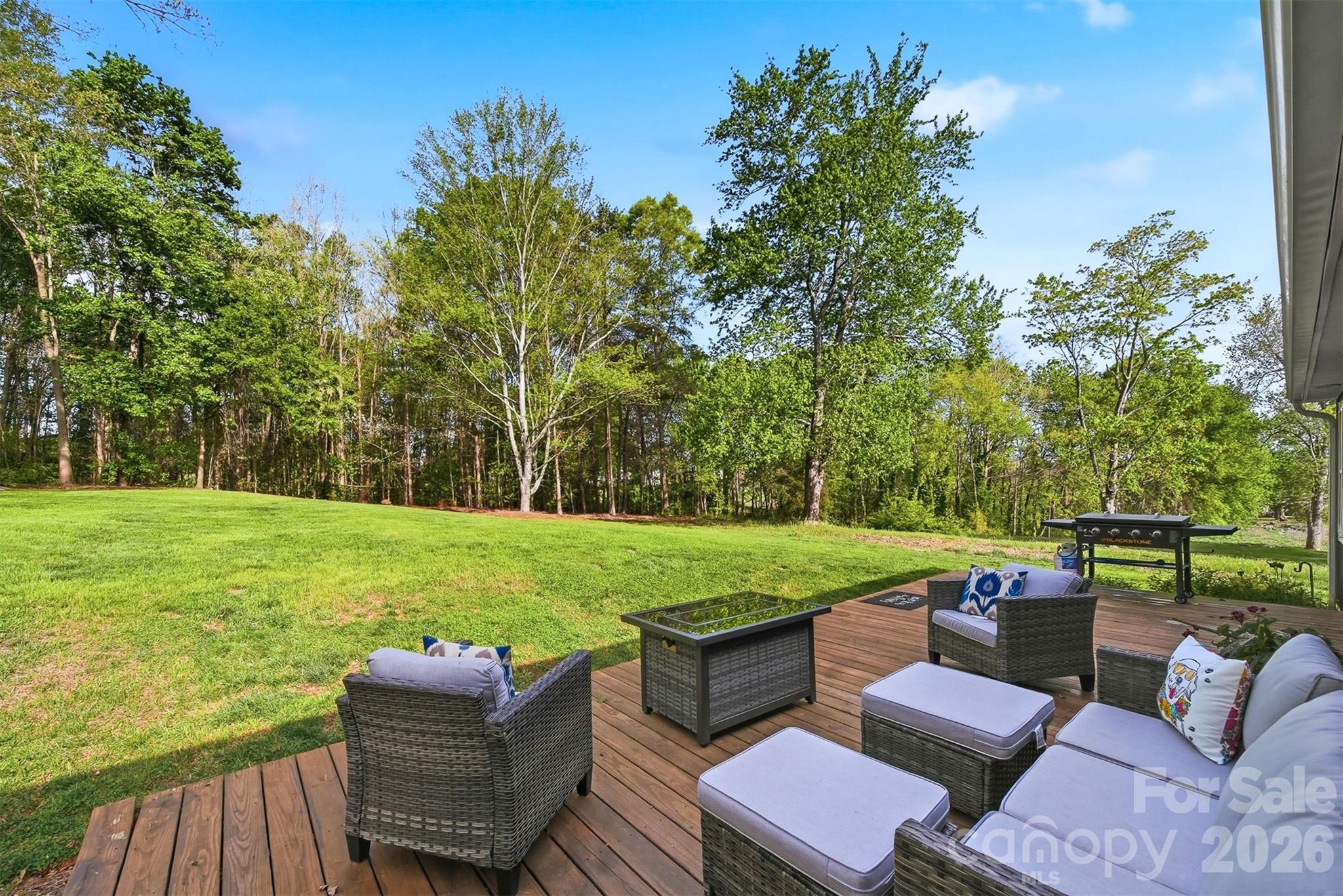 490 Dudley Shoals Road Granite Falls, NC 28630 - Photo 23 of 38 a view of a patio with couches table and chairs under an umbrella with large trees