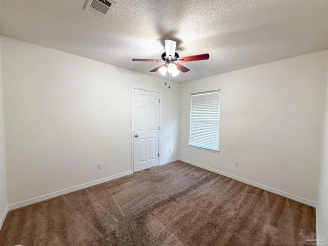 a view of a room with a ceiling fan and a window