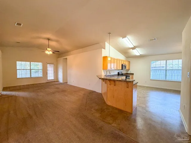 a view of kitchen and kitchen with granite countertop sink