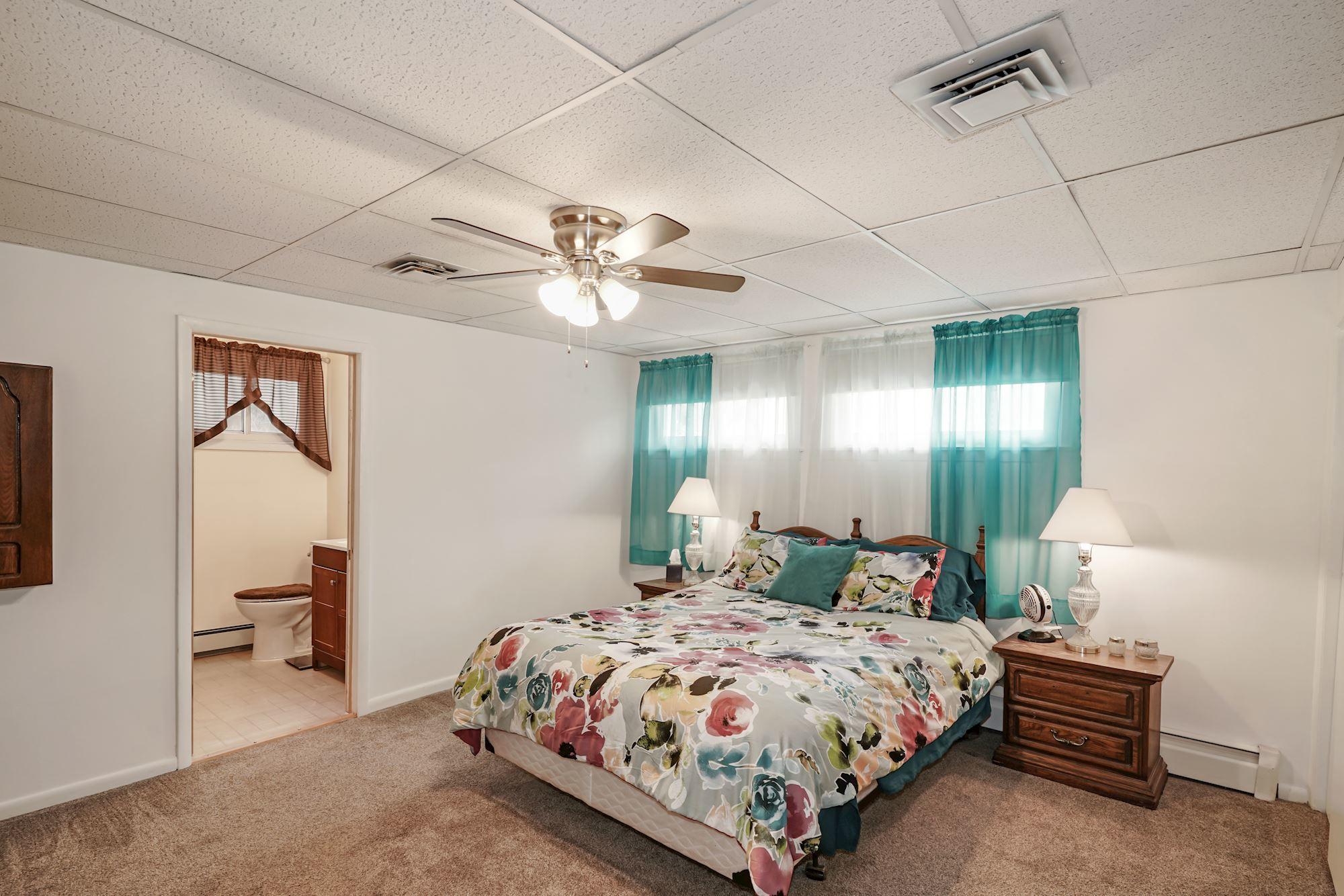 128 Hickory Road Jackson, NJ 08527 - Photo 18 of 25 a bedroom with a bed a lamp and a chandelier