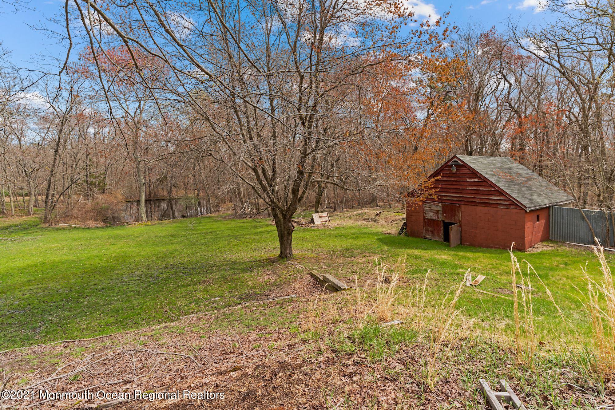 128 Hickory Road Jackson, NJ 08527 - Photo 3 of 25 a backyard of a house with plants and large trees