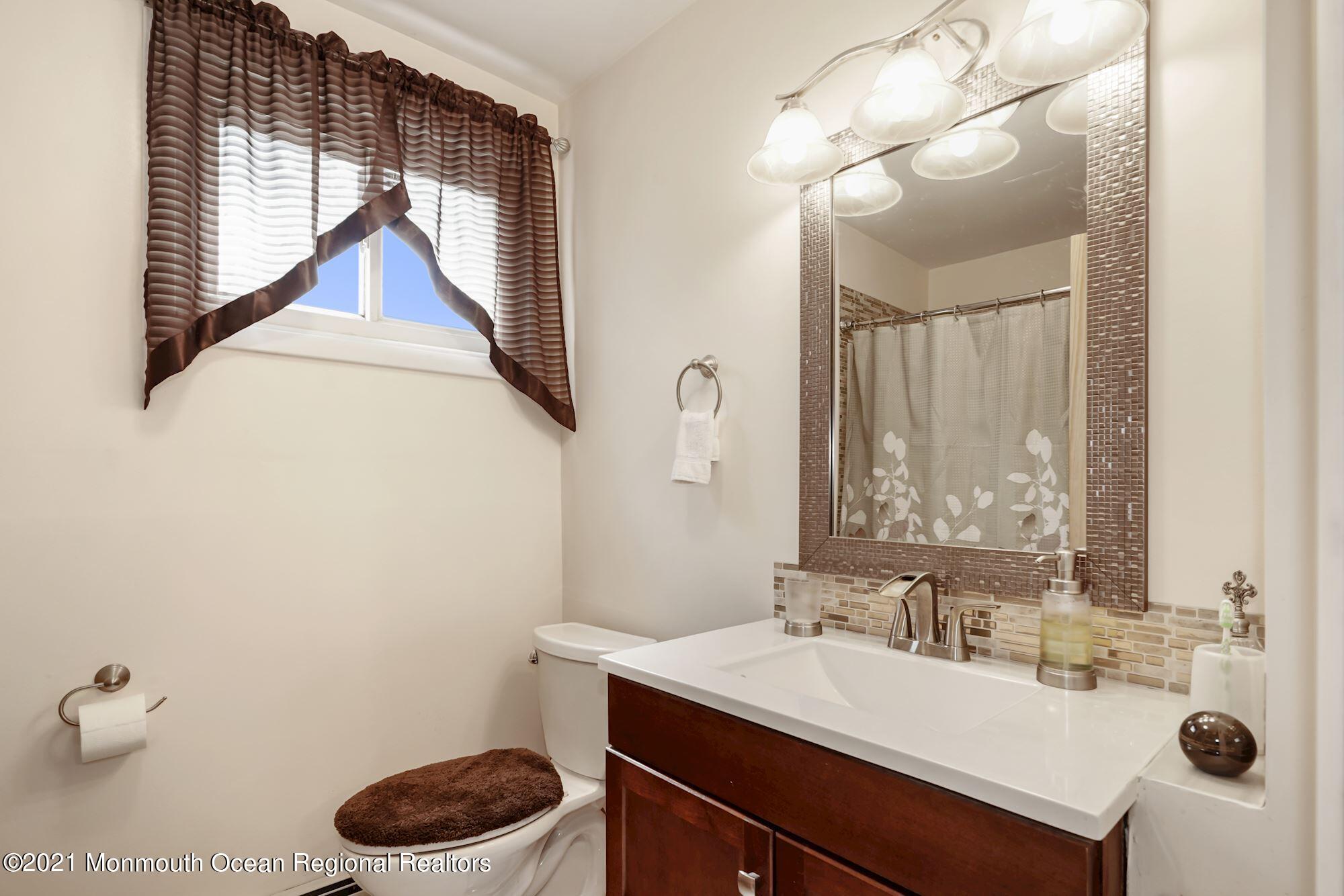 128 Hickory Road Jackson, NJ 08527 - Photo 21 of 25 a bathroom with a sink a toilet and a mirror