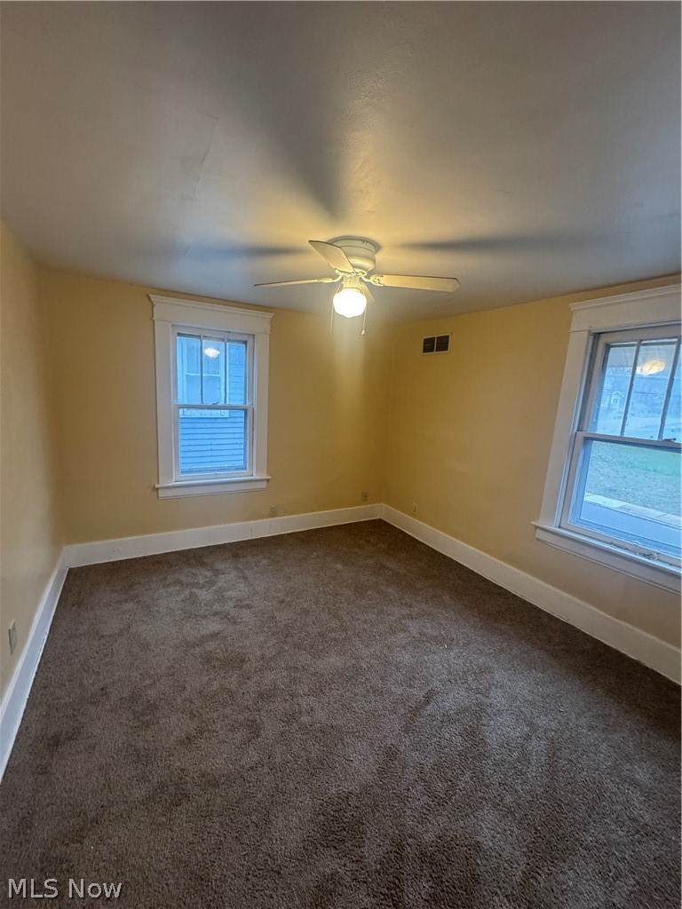 577 Rhodes Avenue Akron, OH 44307 - Photo 12 of 19 Spare room with dark colored carpet and ceiling fan