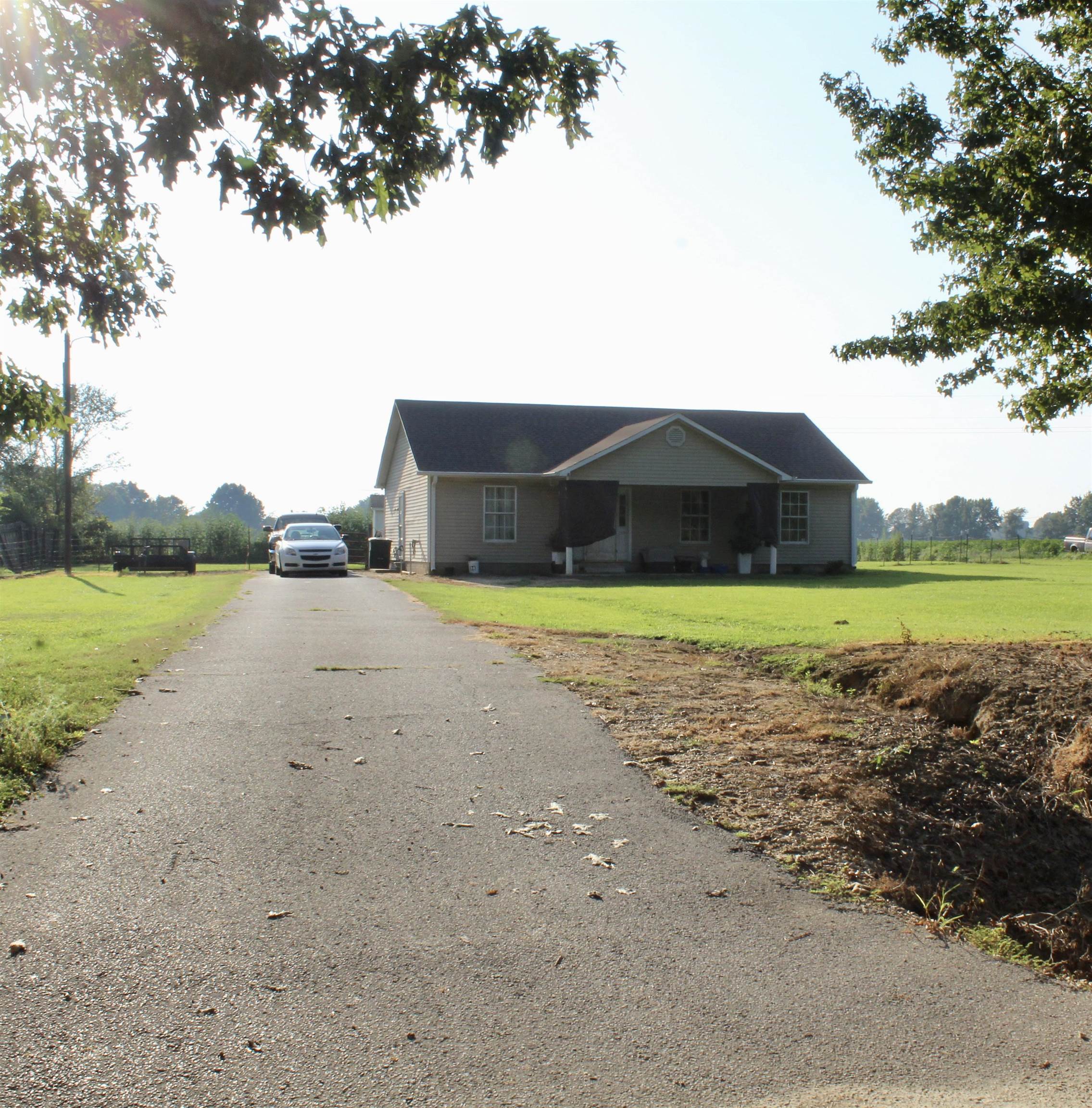 1039 Hyde Road Ripley, TN 38063 - Photo 20 of 21 a view of a lake with lawn chairs and large trees