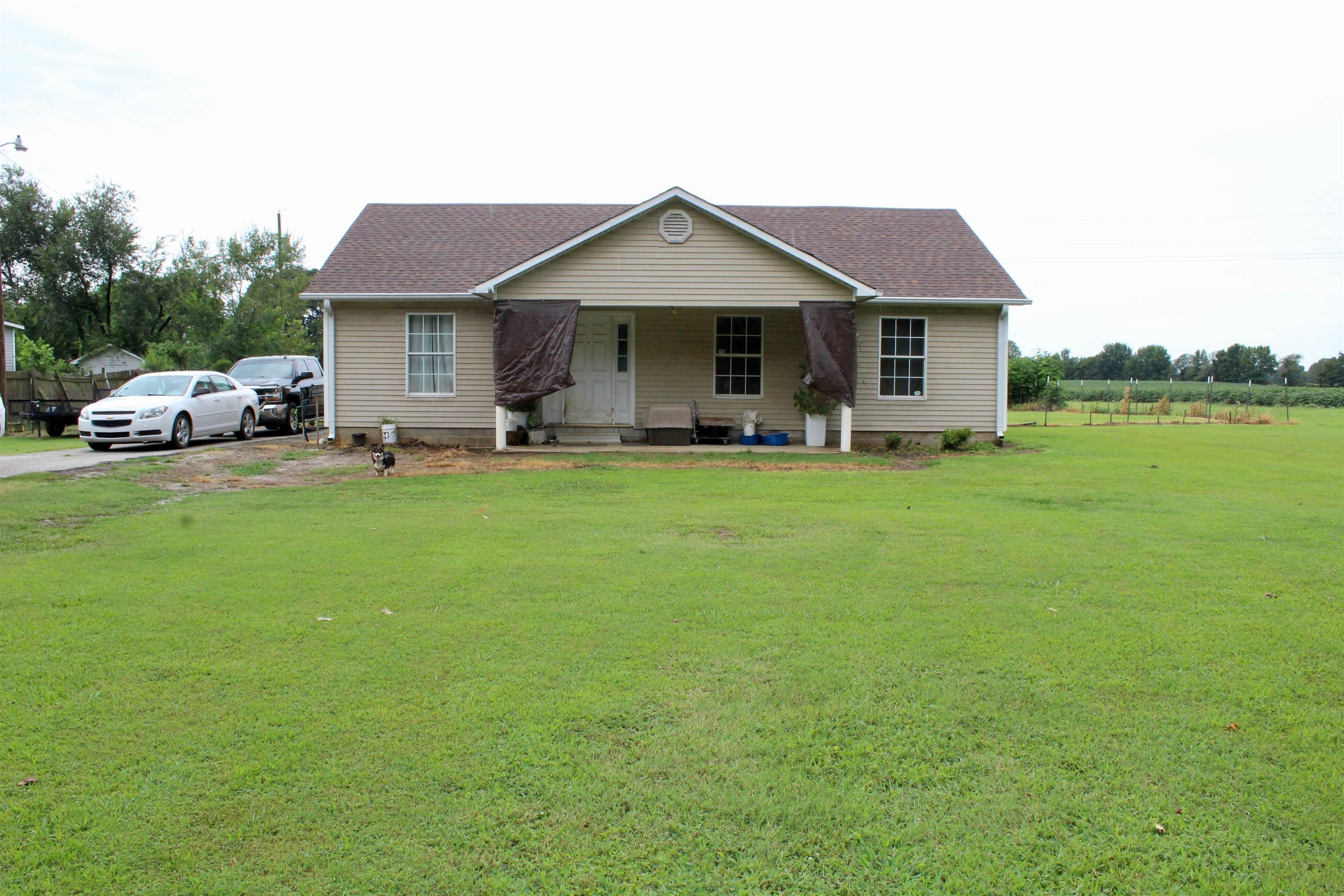1039 Hyde Road Ripley, TN 38063 - Photo 2 of 21 a front view of a house with a garden and trees