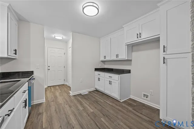 a kitchen with granite countertop white cabinets and white appliances