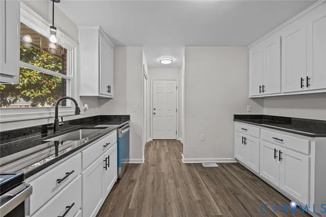 a kitchen with granite countertop white cabinets and white appliances