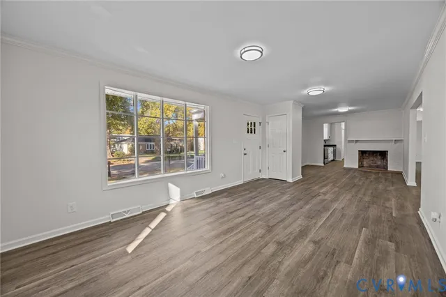 a view of empty room with wooden floor and fireplace
