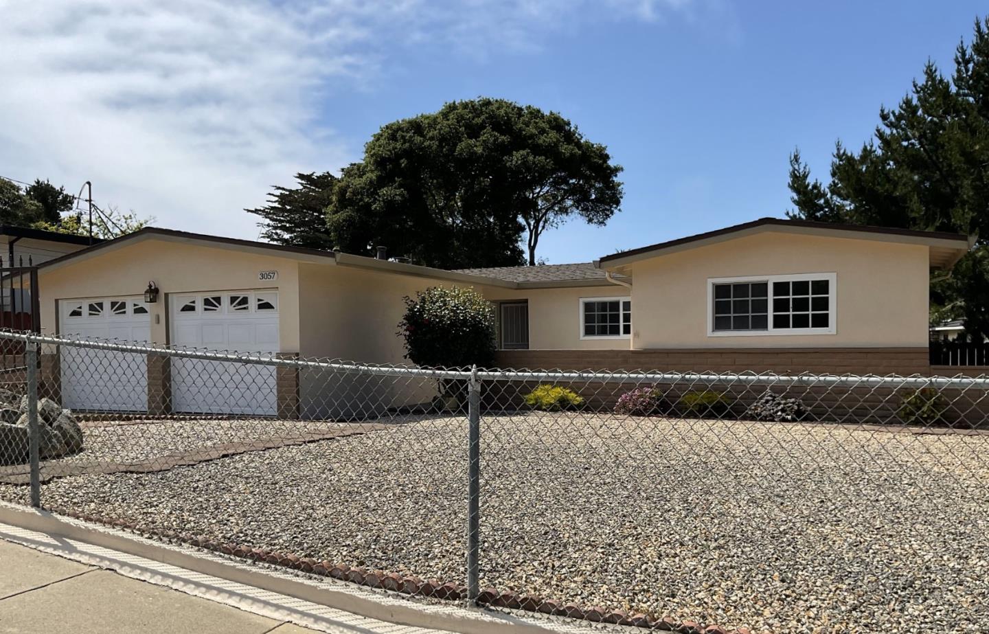 a view of a white house next to a yard
