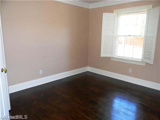 4925 Tower Road, Unit B Greensboro, NC 27410 - Photo 7 of 16 2nd Bedroom. The First Guest Bedroom Includes a Warm Feeling of the Dark Wood Floors all the while being bathed with Sunlight from the large Window