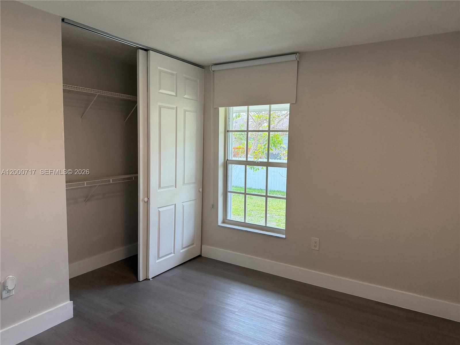 9760 Southwest 210th Street Cutler Bay, FL 33189 - Photo 15 of 17 an empty room with wooden floor closet and windows