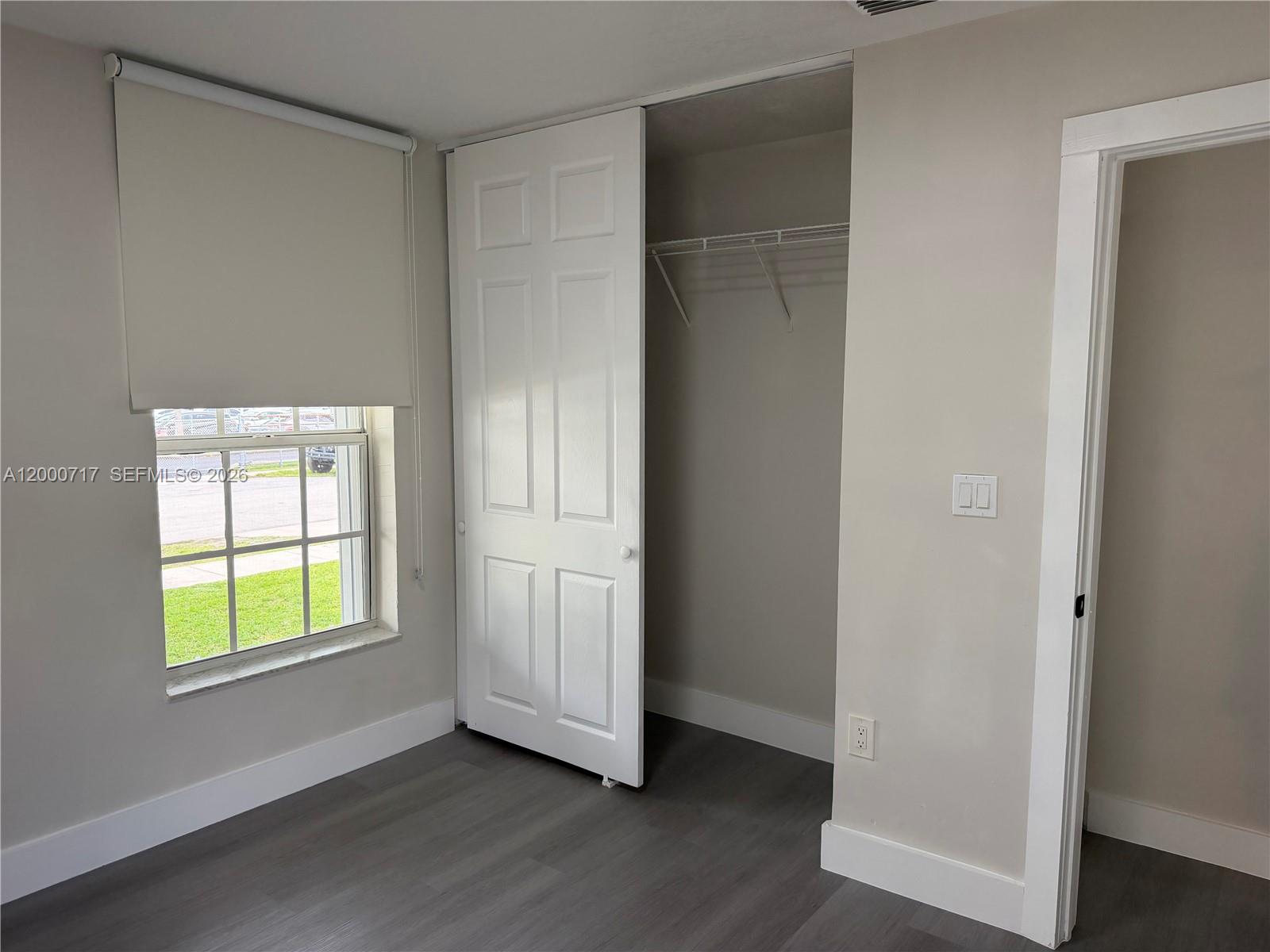 9760 Southwest 210th Street Cutler Bay, FL 33189 - Photo 16 of 17 an empty room with wooden floor closet and windows