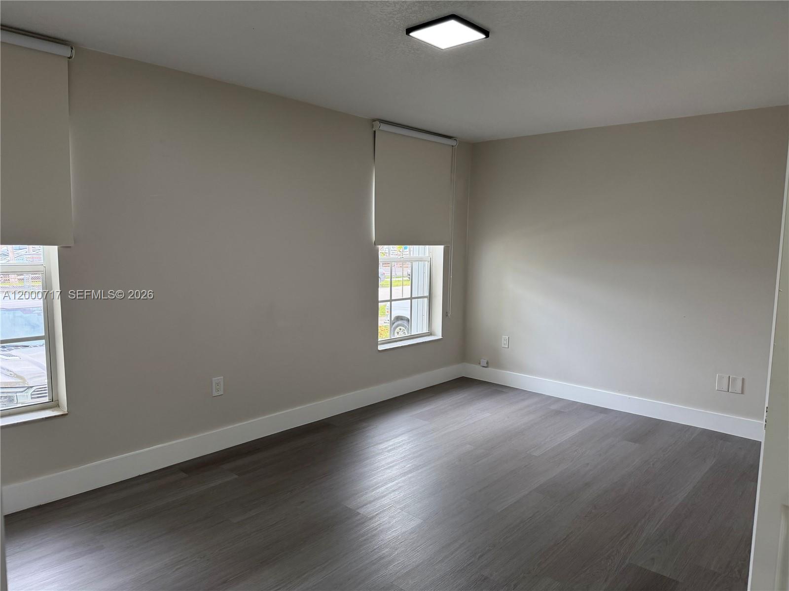 9760 Southwest 210th Street Cutler Bay, FL 33189 - Photo 5 of 17 an empty room with wooden floor and windows