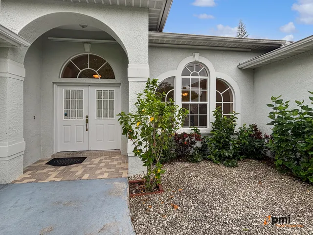 a view of a room with a chandelier fan and windows