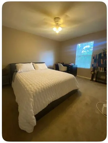 a bed sitting in a room next to a lamp