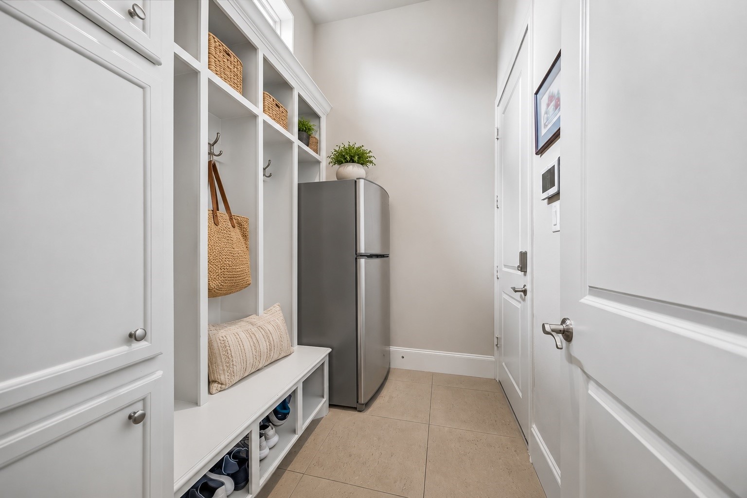 907 Queen Annes Road Houston, TX 77024 - Photo 21 of 31 Functional mudroom with built-in storage lockers, under-bench storage, and additional space for a secondary refrigerator. This image has been virtually staged for illustrative purposes.