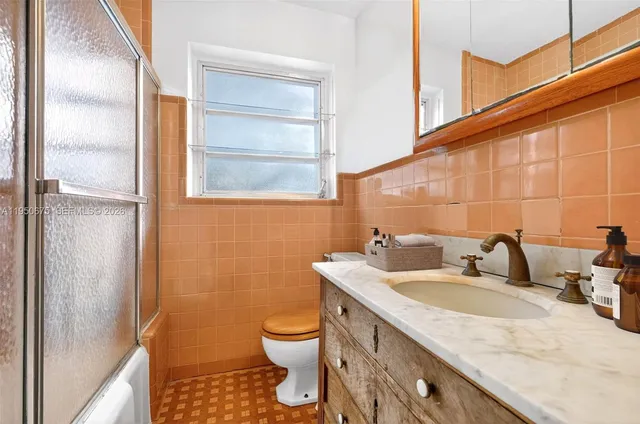 a bathroom with a granite countertop sink toilet and shower