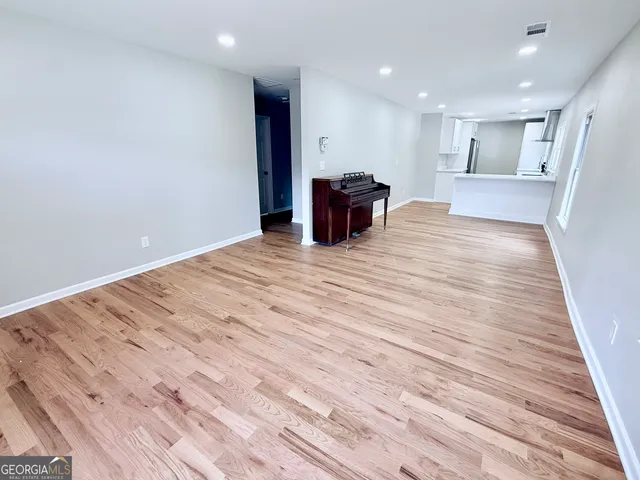 a view of kitchen with kitchen island granite countertop cabinets and wooden floor