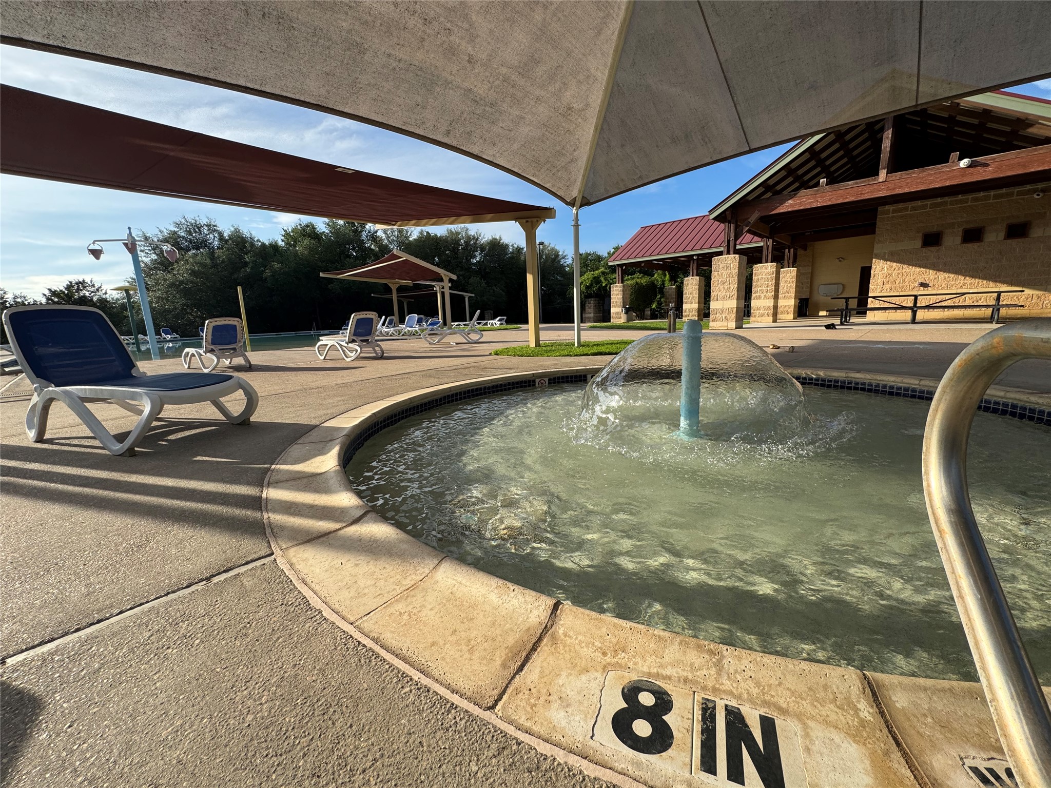 112 Eagle Owl Loop Leander, TX 78641 - Photo 30 of 34 Circular water feature with fountain, surrounded by concrete decking and shade structures