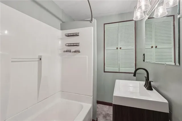 a bathroom with a sink a shower and a mirror