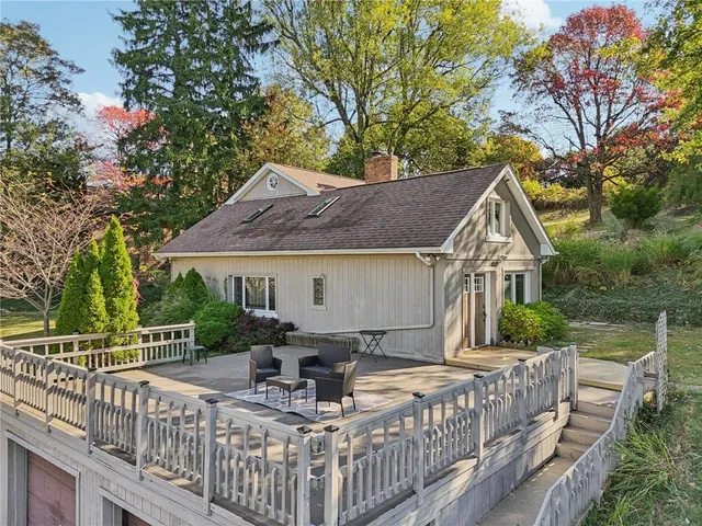 a view of house with wooden deck and barbeque oven
