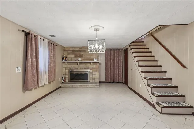a view of a livingroom with a fireplace stairs and a window