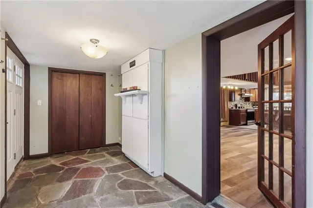 a view of a hallway with wooden cabinets and refrigerator