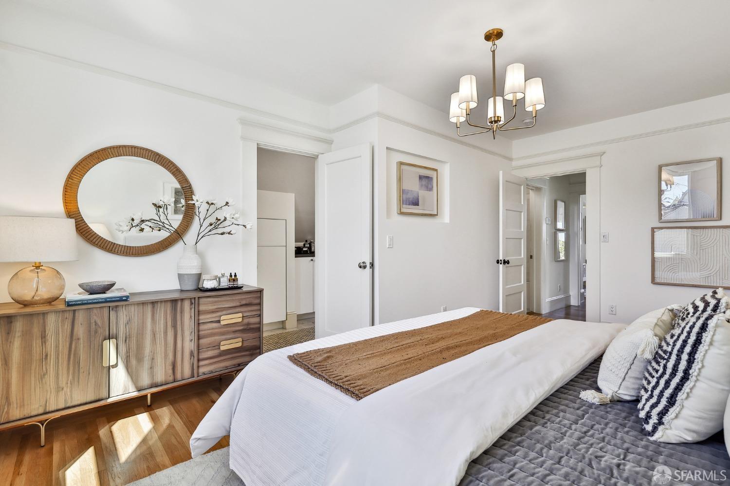 216 Ellsworth Street San Francisco, CA 94110 - Photo 20 of 76 a bedroom with a bed a chandelier a mirror and a table
