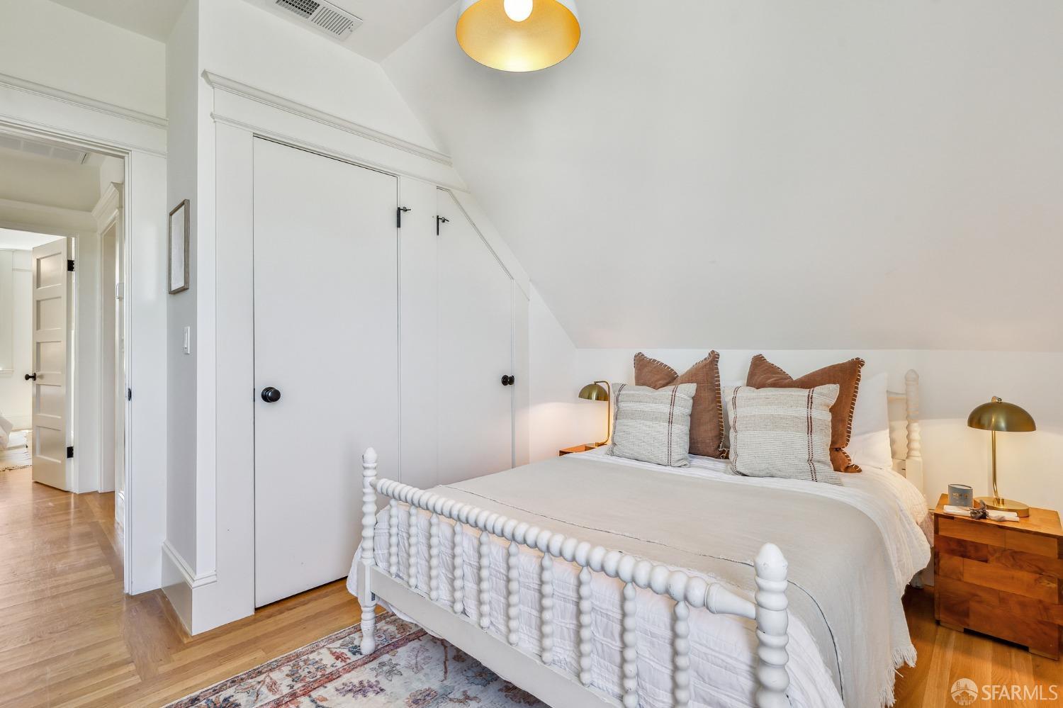 216 Ellsworth Street San Francisco, CA 94110 - Photo 28 of 76 a bedroom with a bed and wooden floor