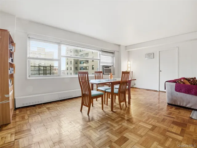a dining room with furniture and a floor to ceiling window