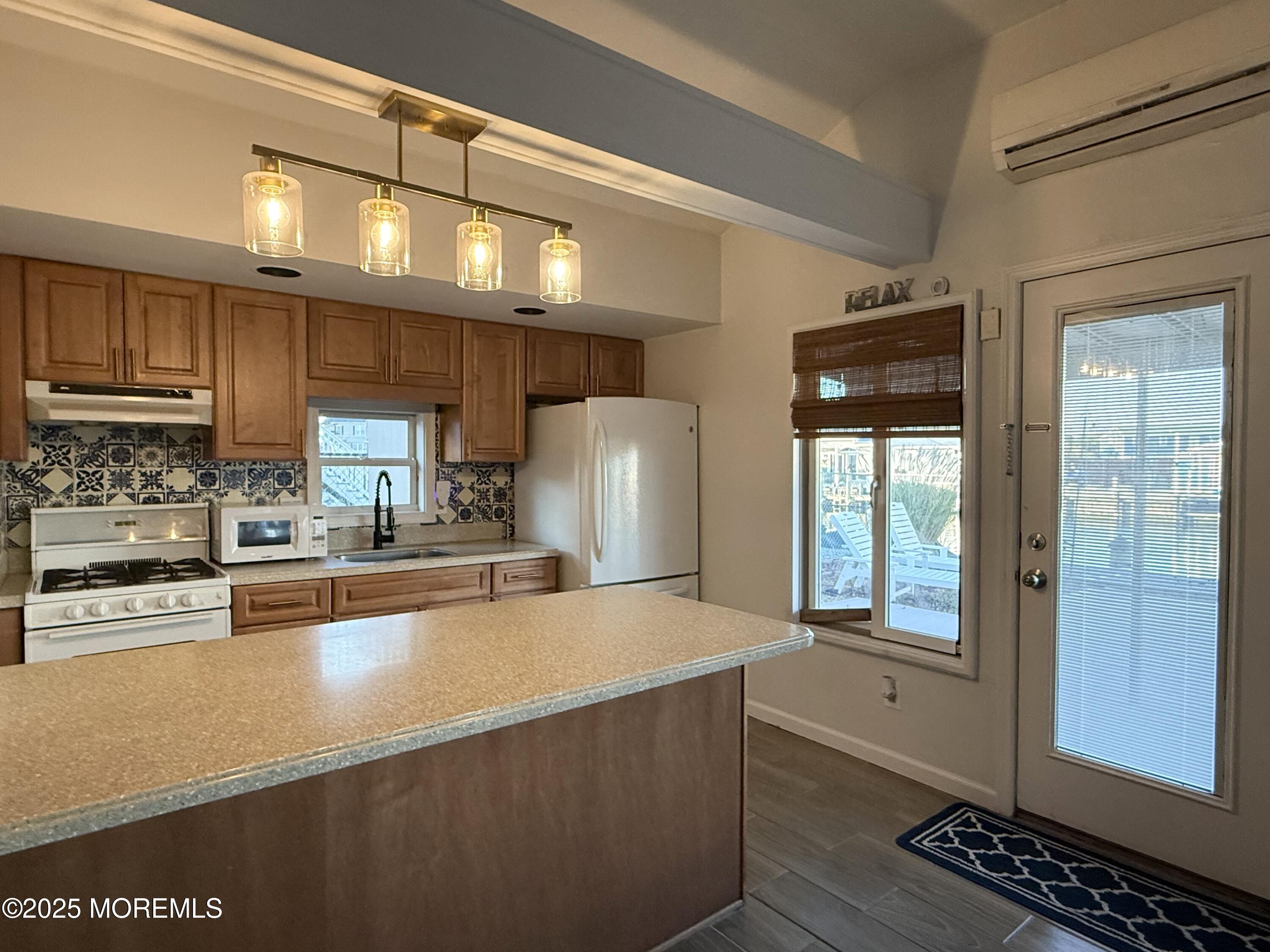 237 Butler Boulevard Bayville, NJ 08721 - Photo 5 of 25 a large kitchen with stainless steel appliances a large counter top a stove and a refrigerator
