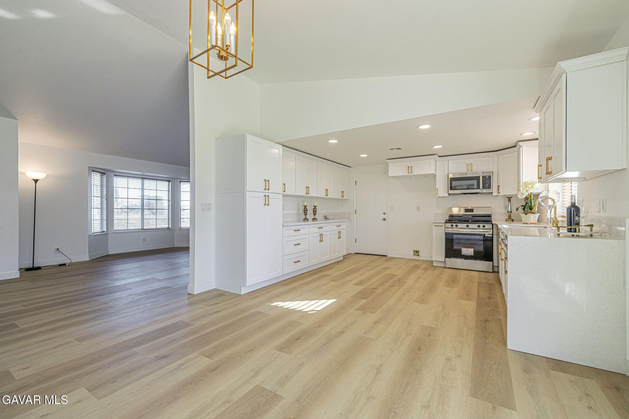 a view of open kitchen with wooden floor and electronic appliances