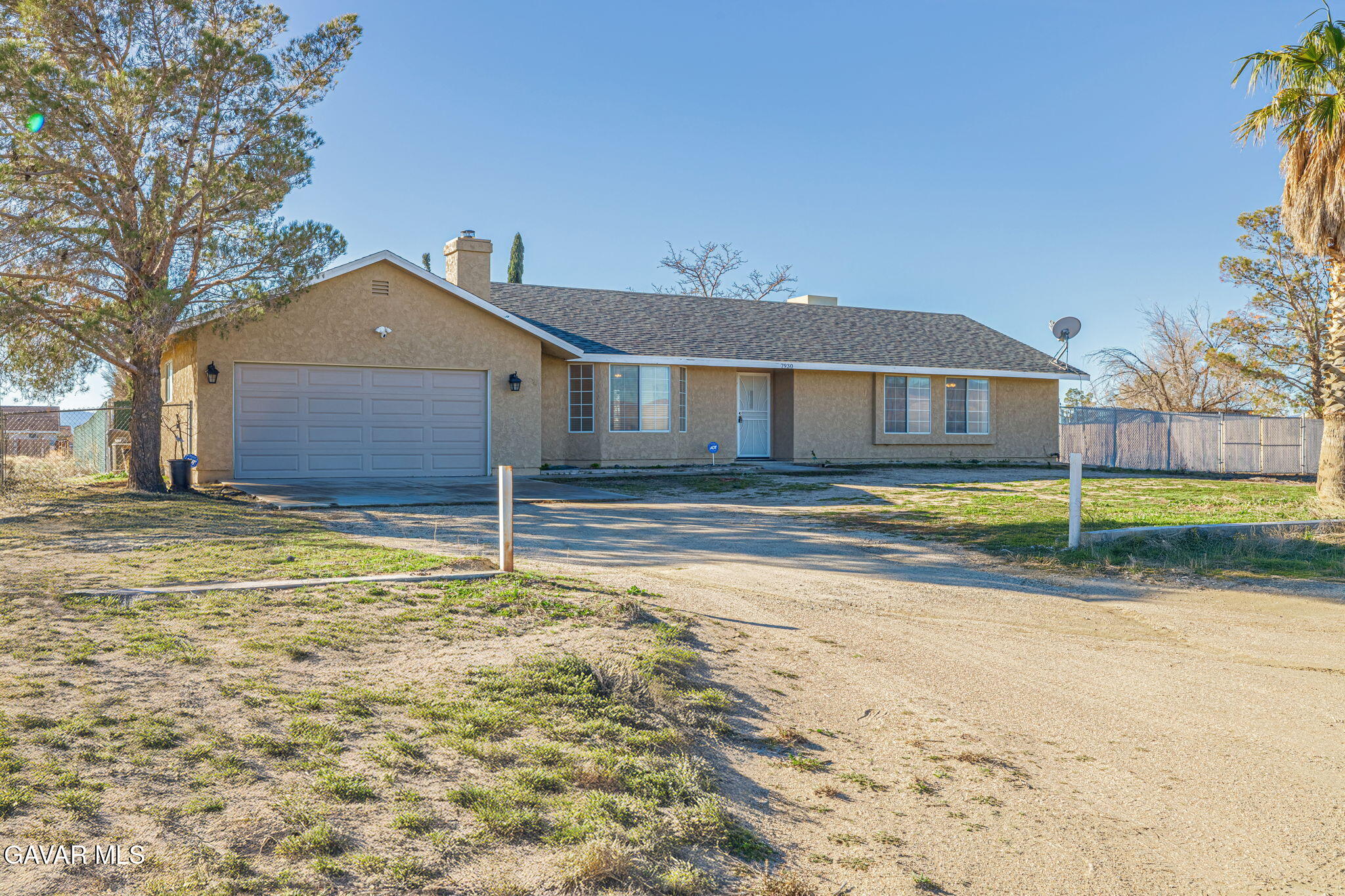 7930 Elder Avenue Rosamond, CA 93560 - Photo 14 of 35 a house that has a big yard and a large trees with wooden fence