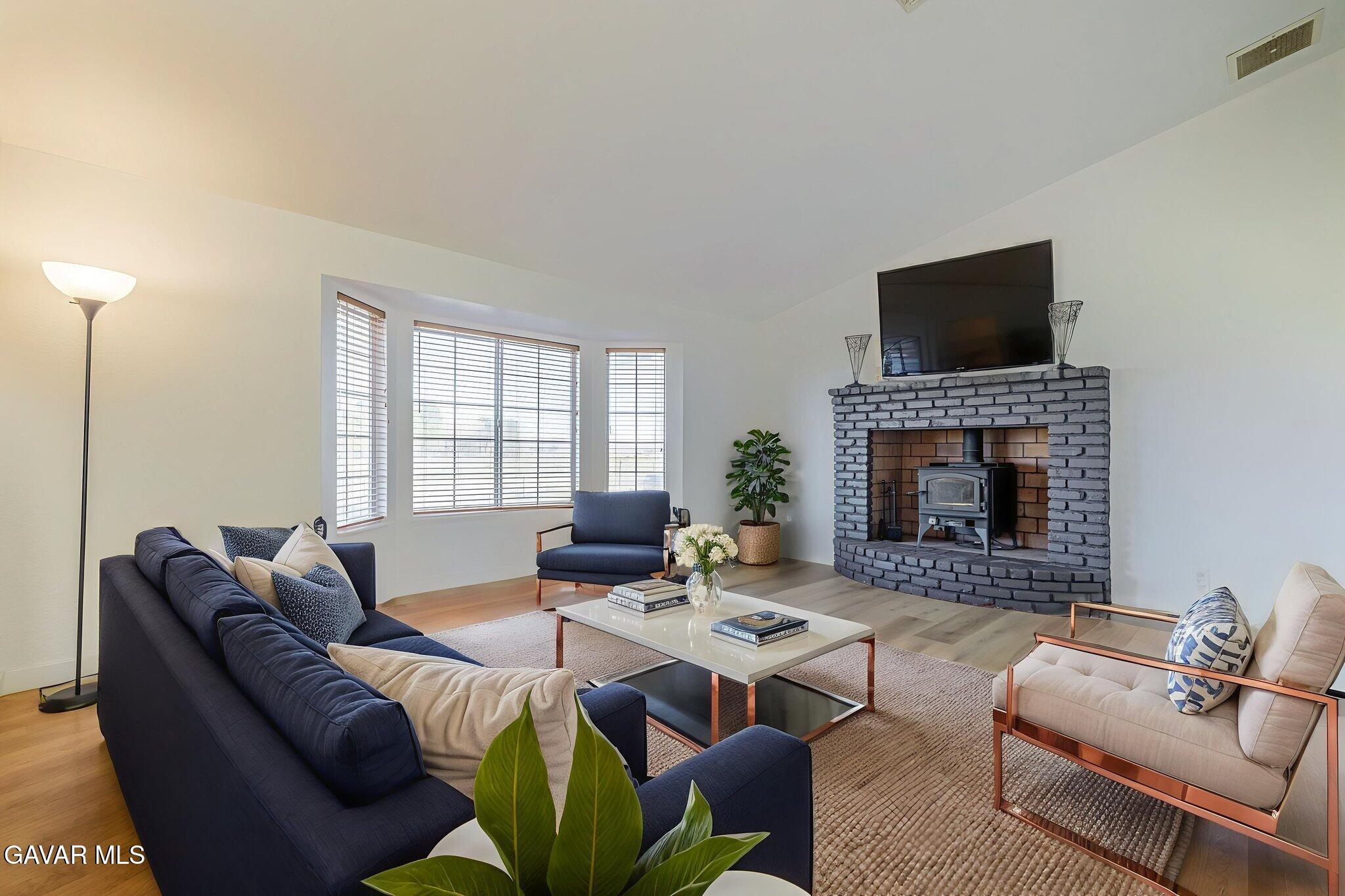 7930 Elder Avenue Rosamond, CA 93560 - Photo 15 of 35 a living room with furniture a flat screen tv and a fireplace