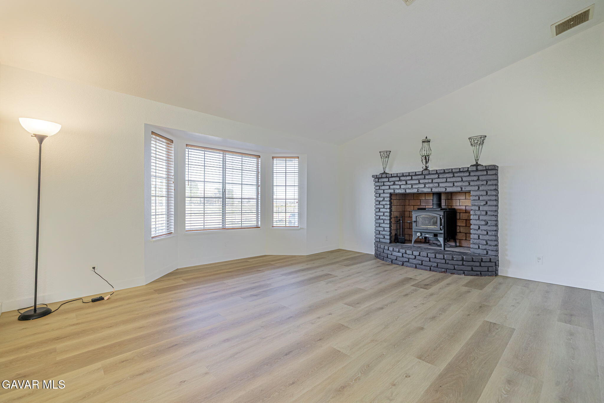 7930 Elder Avenue Rosamond, CA 93560 - Photo 16 of 35 an empty room with windows and fireplace