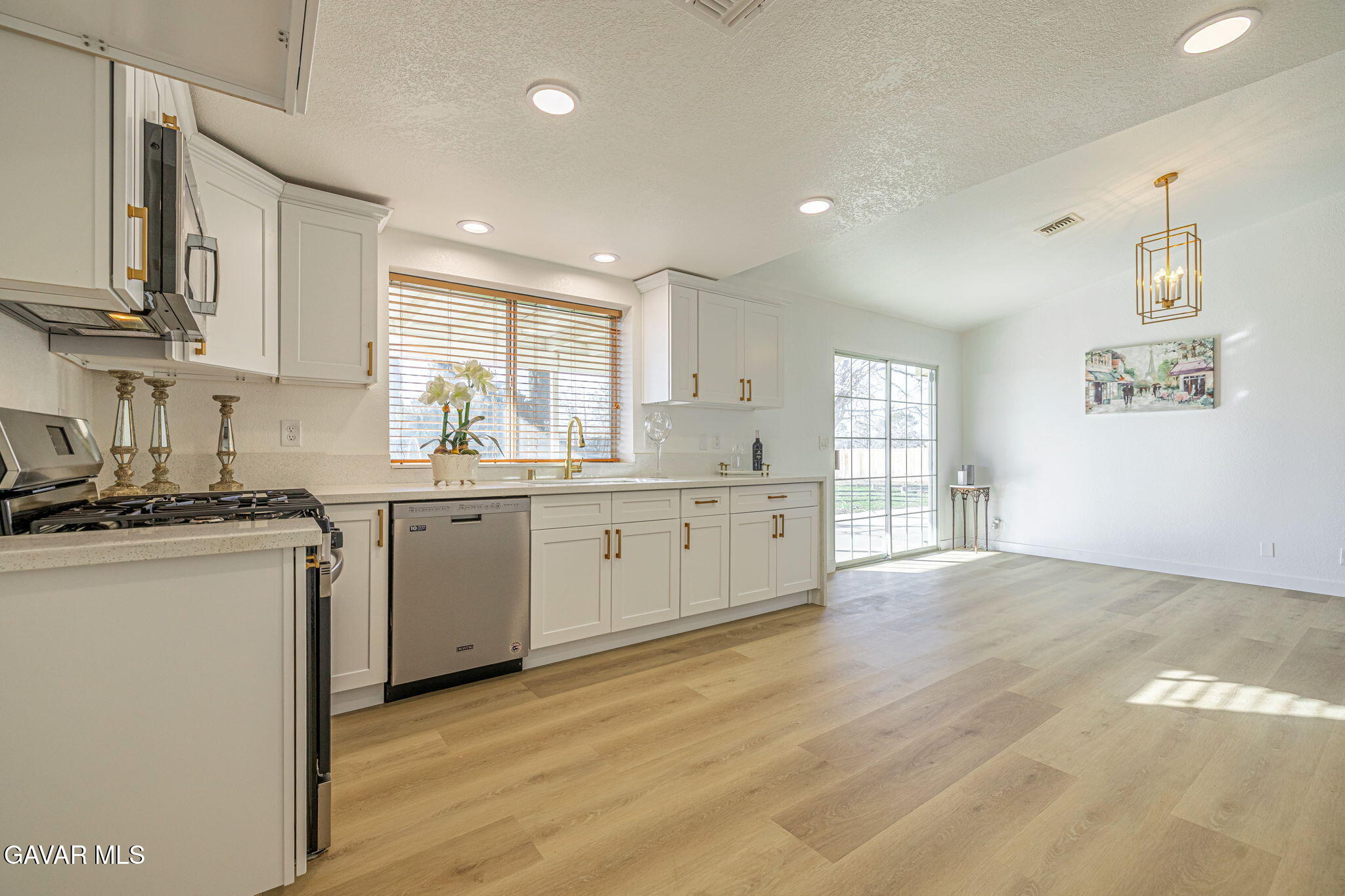 7930 Elder Avenue Rosamond, CA 93560 - Photo 19 of 35 a kitchen with stainless steel appliances granite countertop a sink cabinets and wooden floor