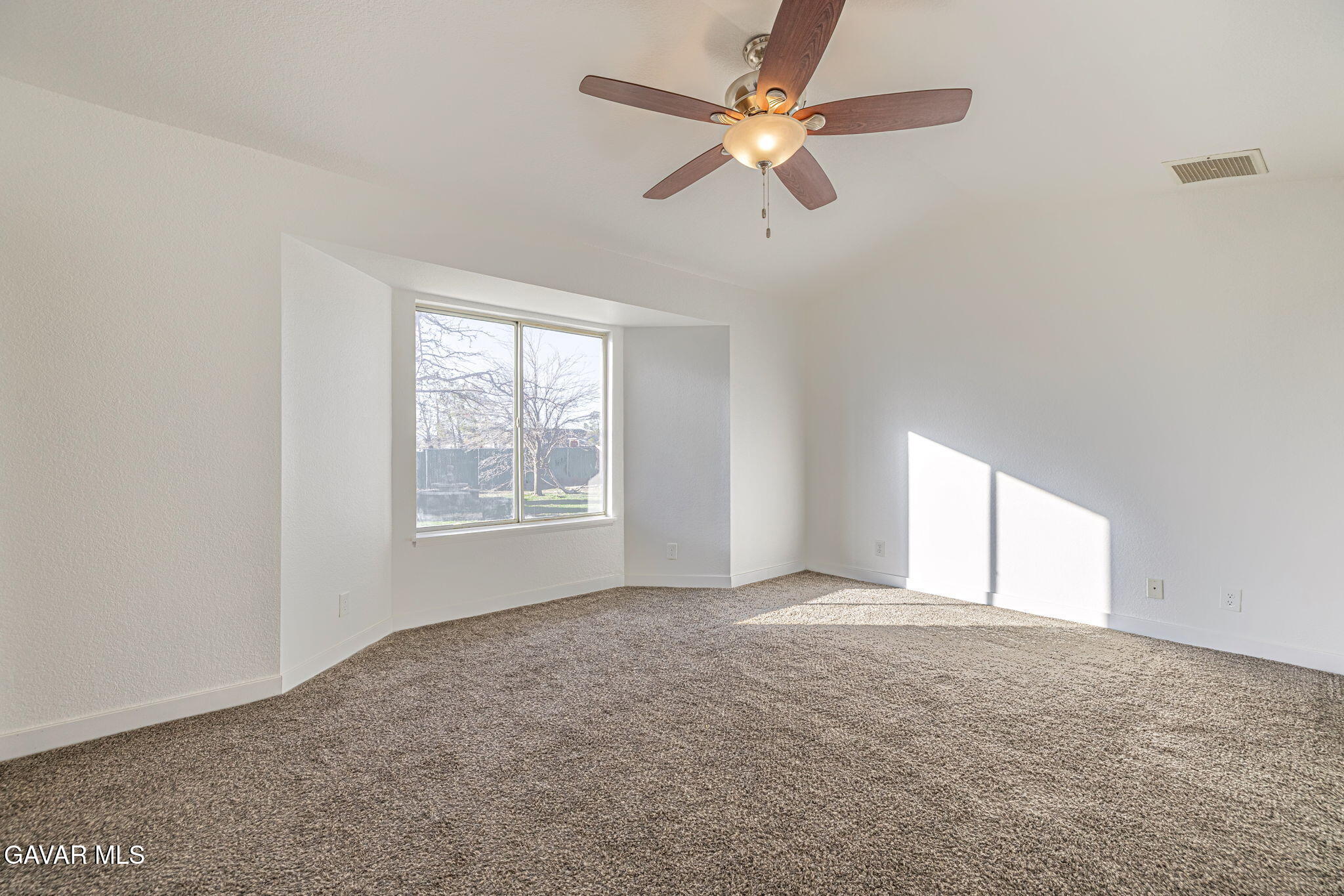 7930 Elder Avenue Rosamond, CA 93560 - Photo 6 of 35 an empty room with a window and a fan