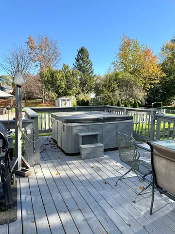 a view of a roof deck with table and chairs with wooden floor and fence
