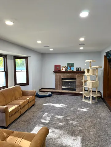 a living room with furniture a fireplace and a large window