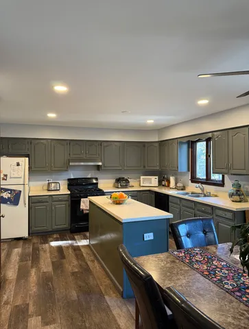a kitchen that has a lot of cabinets a sink and a stove in it