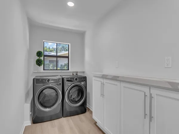 a view of a backyard with lawn chairs under an umbrella