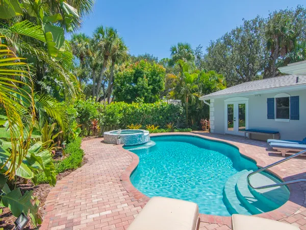 a view of a patio with table and chairs potted plants and large tree
