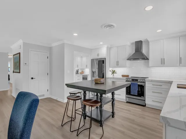 a kitchen with stainless steel appliances a dining table and chairs