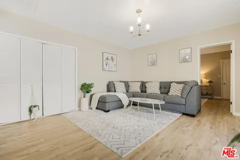a living room with furniture and a chandelier